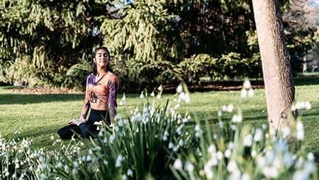 Adult woman sitting on the grass meditating