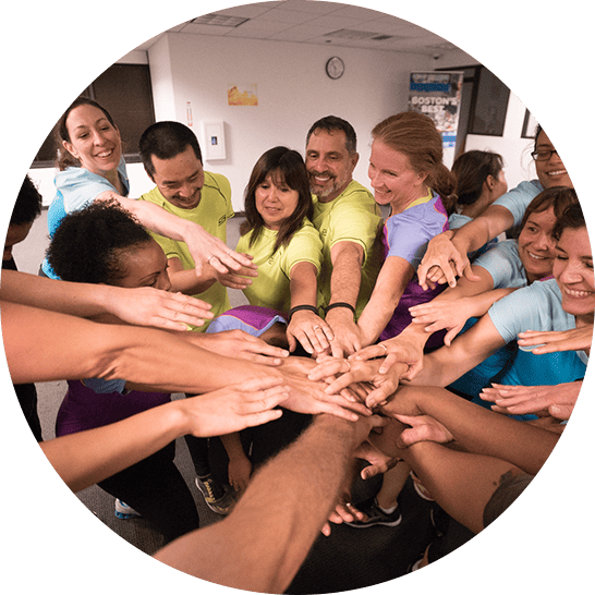 Students putting their hands in the middle of the circle