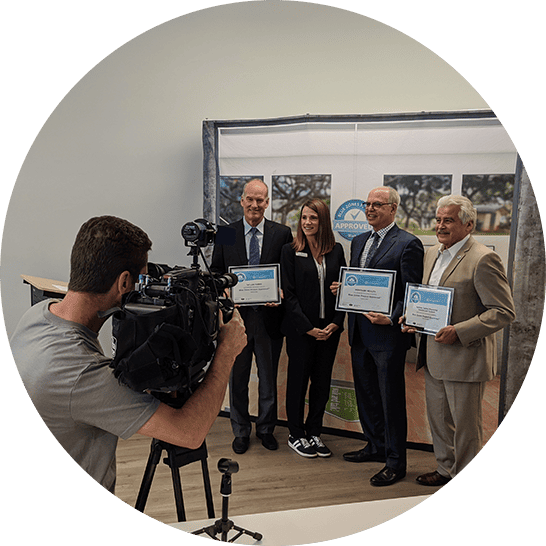 Employees taking photos for press to celebrate becoming an approved organization