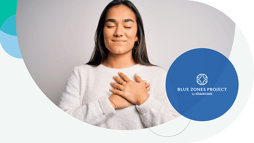 Women closing her eyes smiling with hands over heart