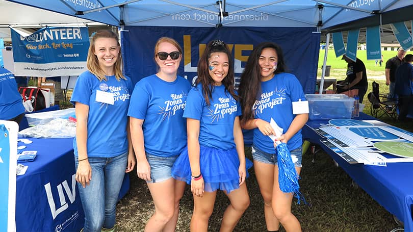 Four young adult volunteers tabling at a community event