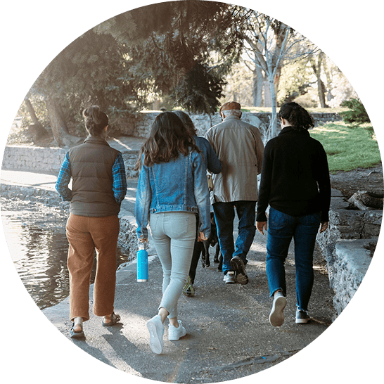 Group of five adults walking away along a lake