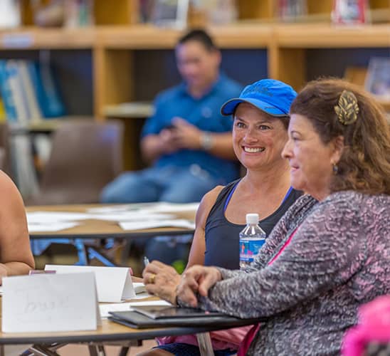 Two women sitting at a table at a Purpose Workshop