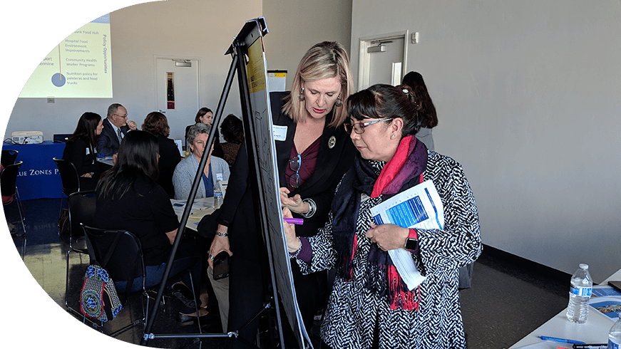 Two women in front of a board in a meeting