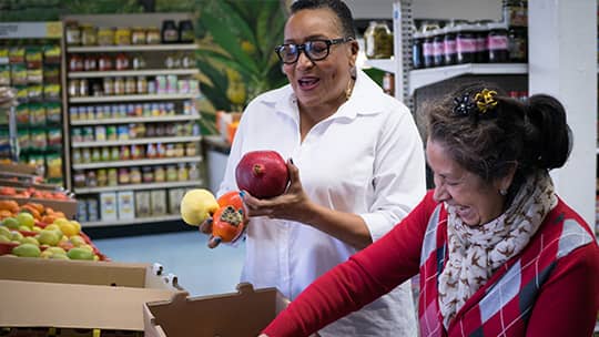 Two women looking at produce in a grocery store