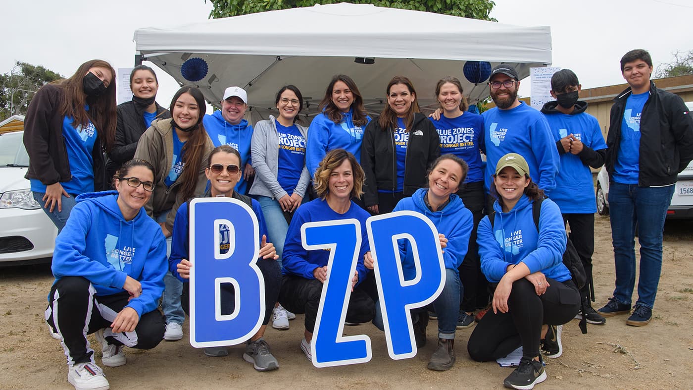 Blue Zones Project colleagues holding signs that read BZP