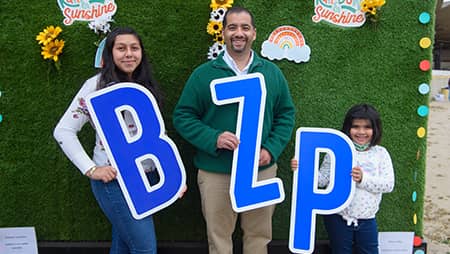Family of three holding BZP signs.
